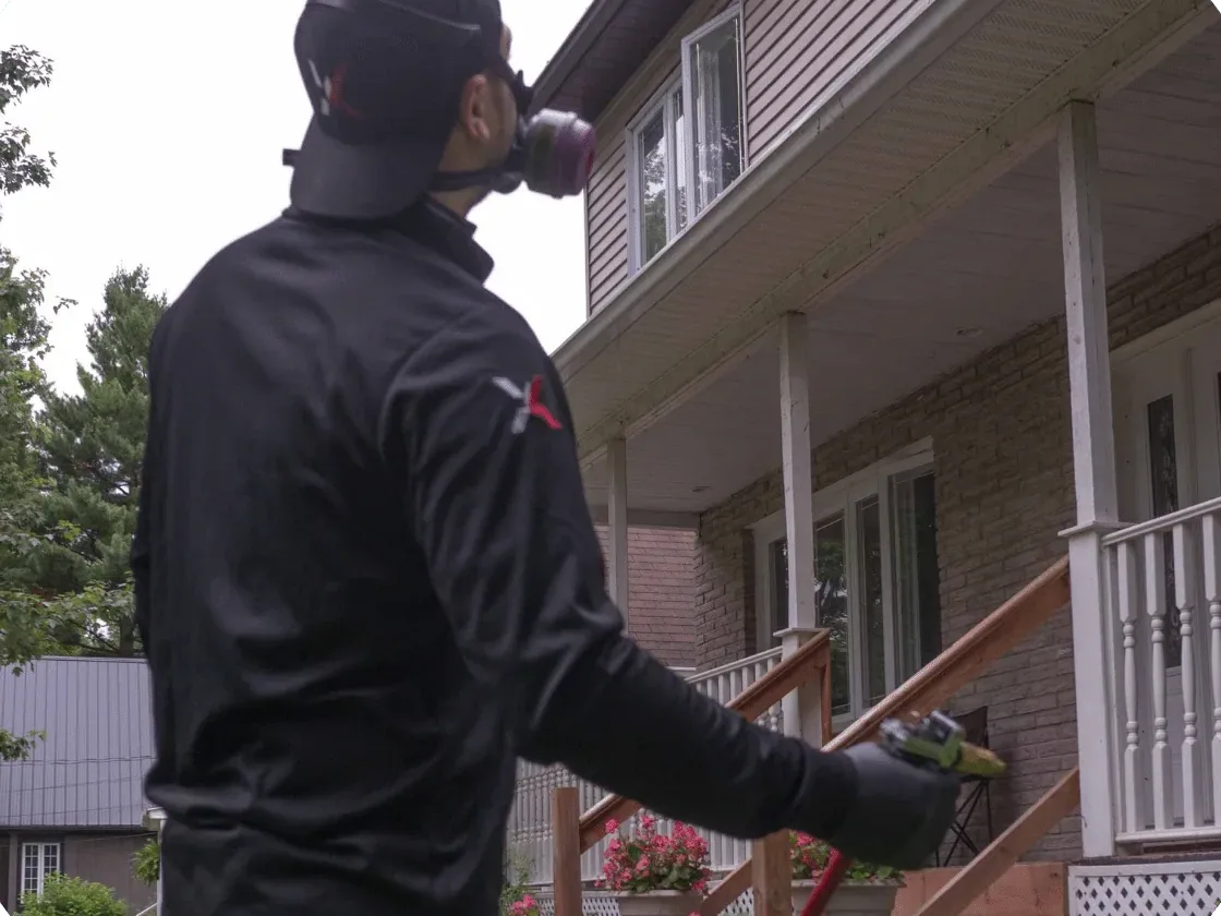 Exterminatek technician performing exterior spraying